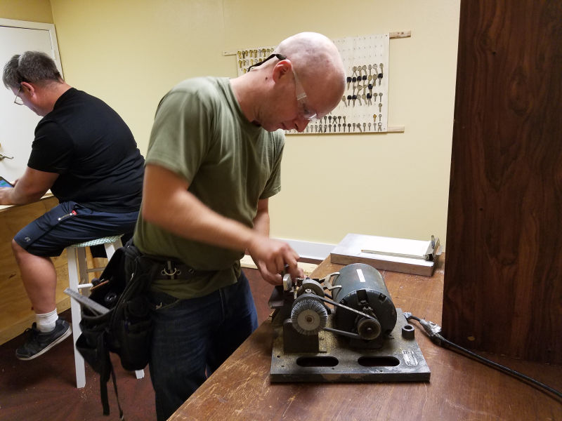 A locksmith uses a grinder to create keys