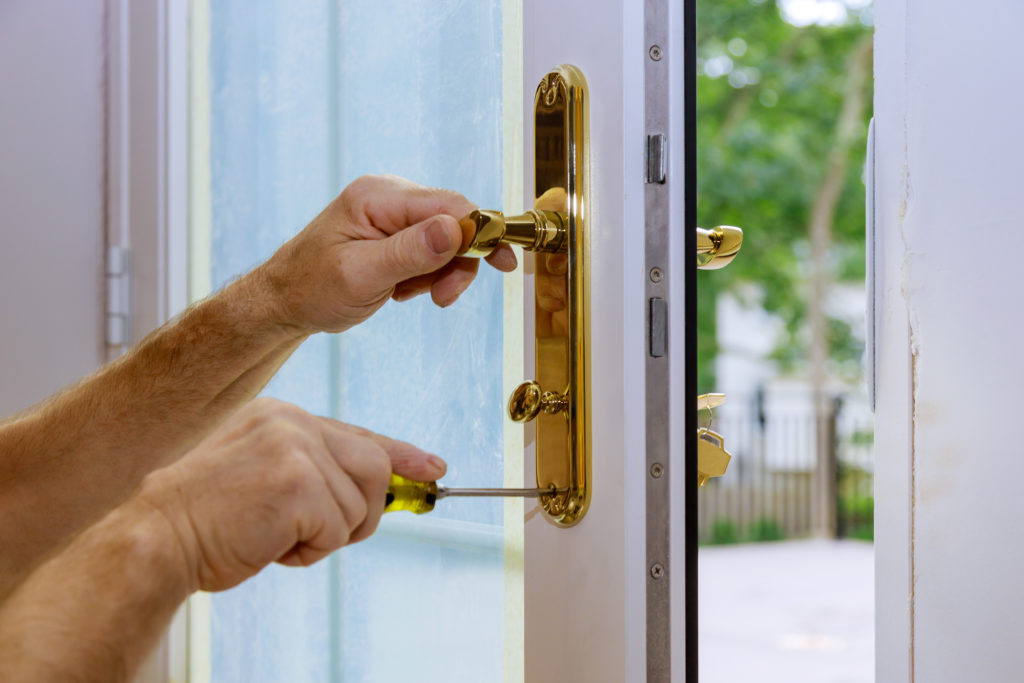 A locksmith changing the locks on a glass door