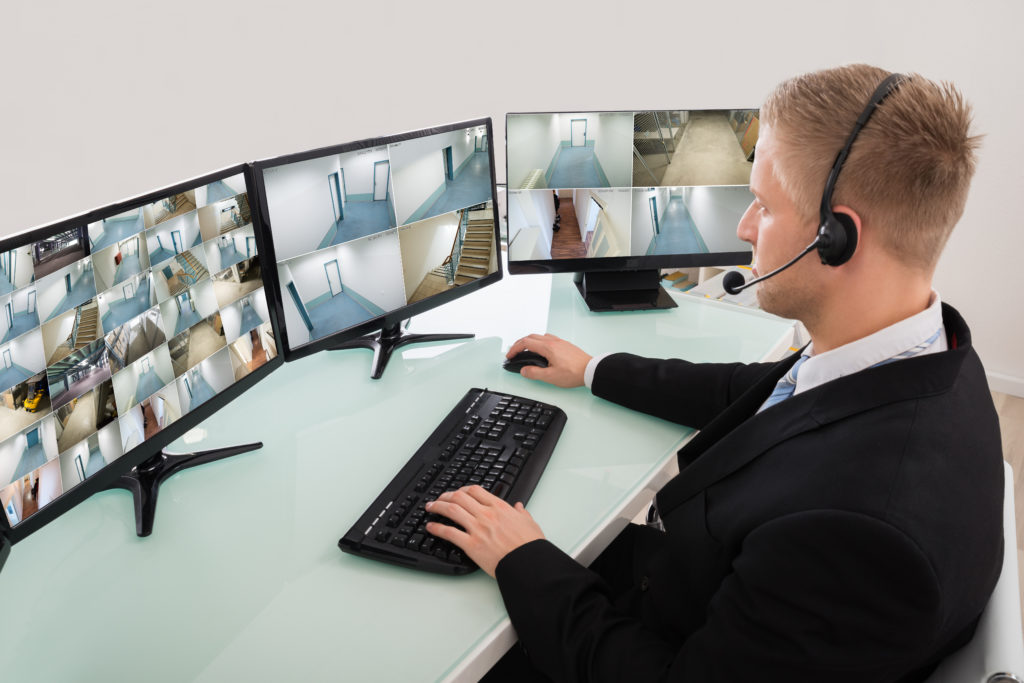 Security officer watches cameras on multiple screens