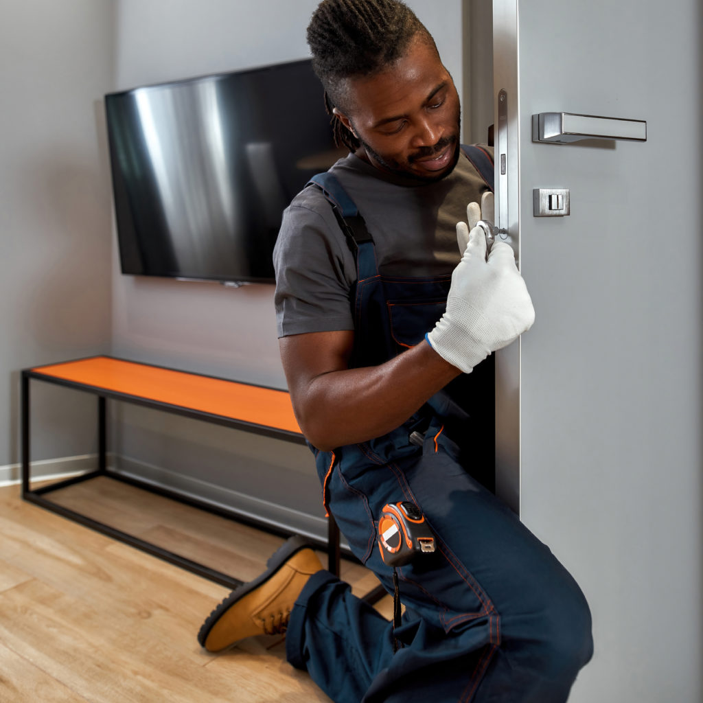 A locksmith fixing lock on apartment door