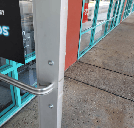 Commercial locksmith in Waco TX repairing glass storefront door