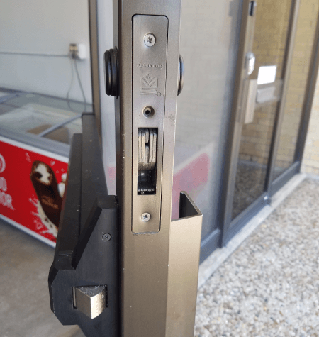Commercial locksmith in Temple TX installing storefront door lock