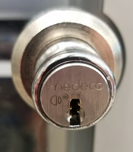 Medeco high security deadbolt lock installed on a commercial door